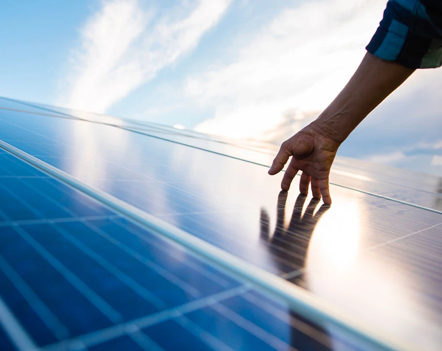 Una mano che sfiora impianti fotovoltaici